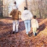 Family walking on a path in an autumn forest